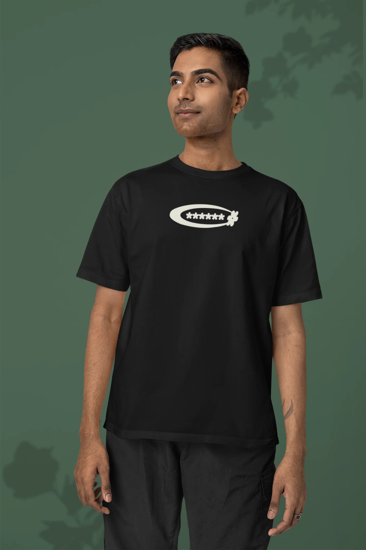 First front of a male model model wearing a black with a design featuring berry bushes overflowing with fruit, symbolizing the abundance and beauty of nature.