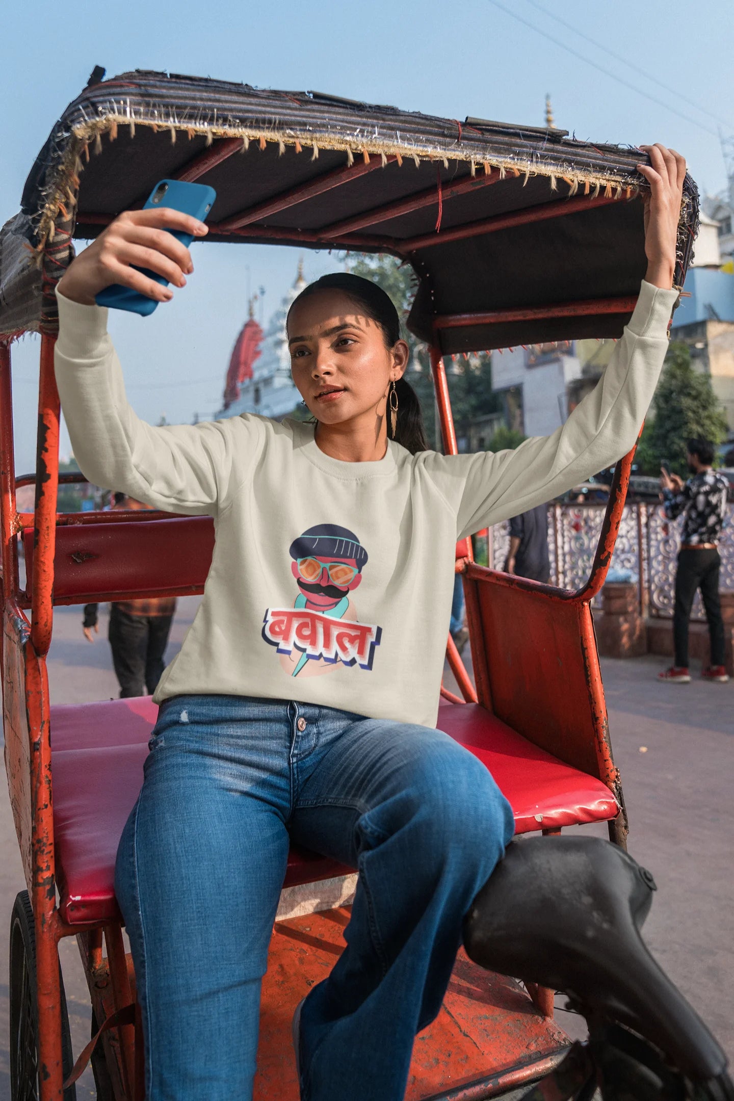 3rd front view of a female model wearing a cream oversized t-shirt with "Bawaal" in a stylish Hindi.