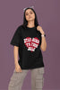 First front view of a female model wearing a black oversized t-shirt with the text 