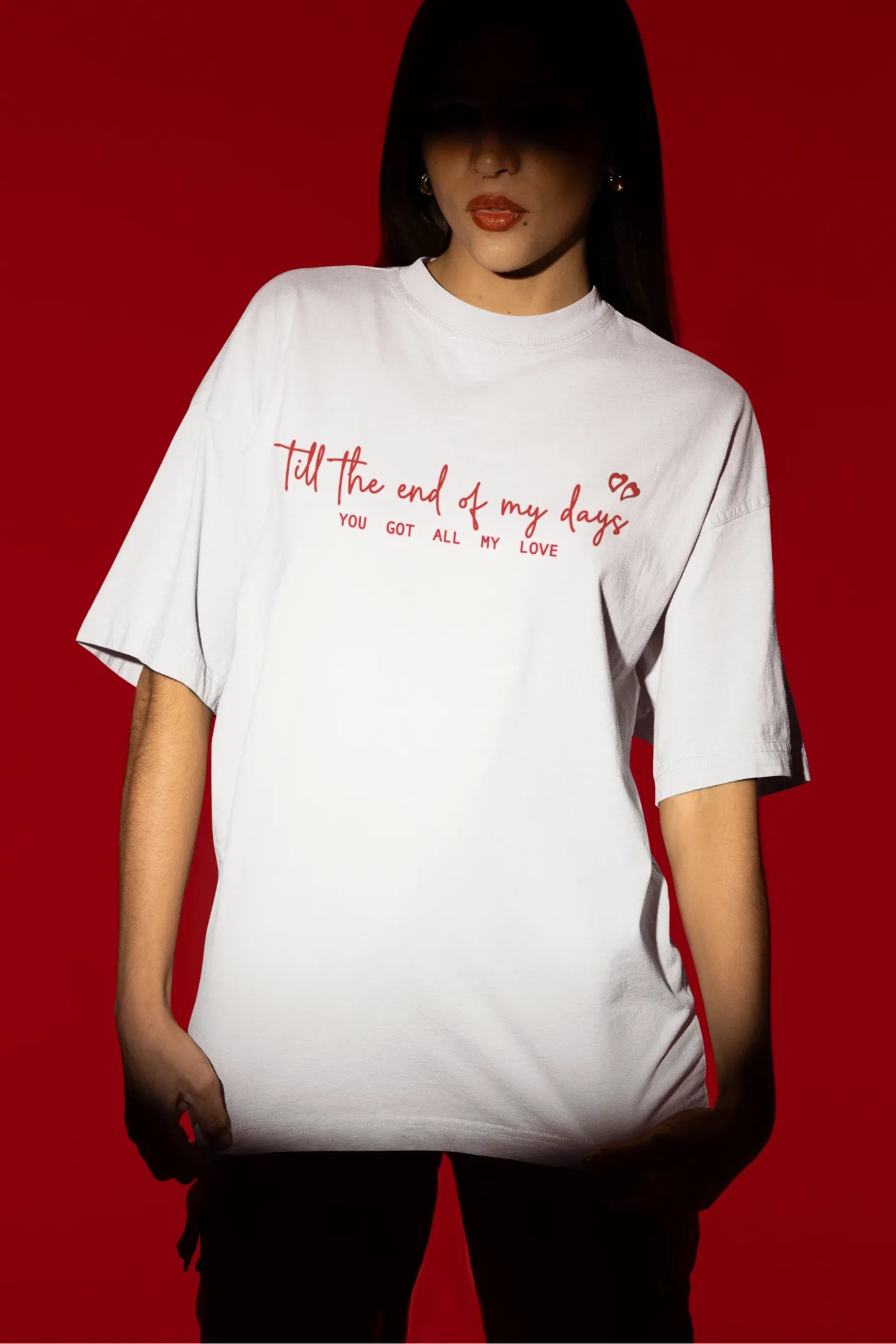 Second front view of a female model wearing a off-white oversized t-shirt with a heart design and the text "All My Love".