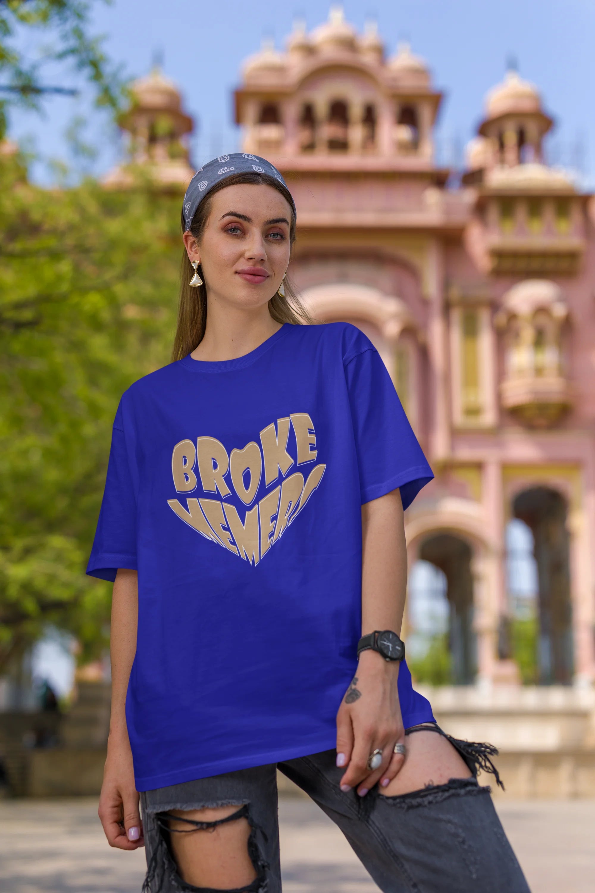 First front view of female model wearing a royal blue oversized t-shirt featuring the "Broke Memers" logo creatively shaped like a heart. Ideal for fans of Broke Memers who love quality and fashionable clothing.