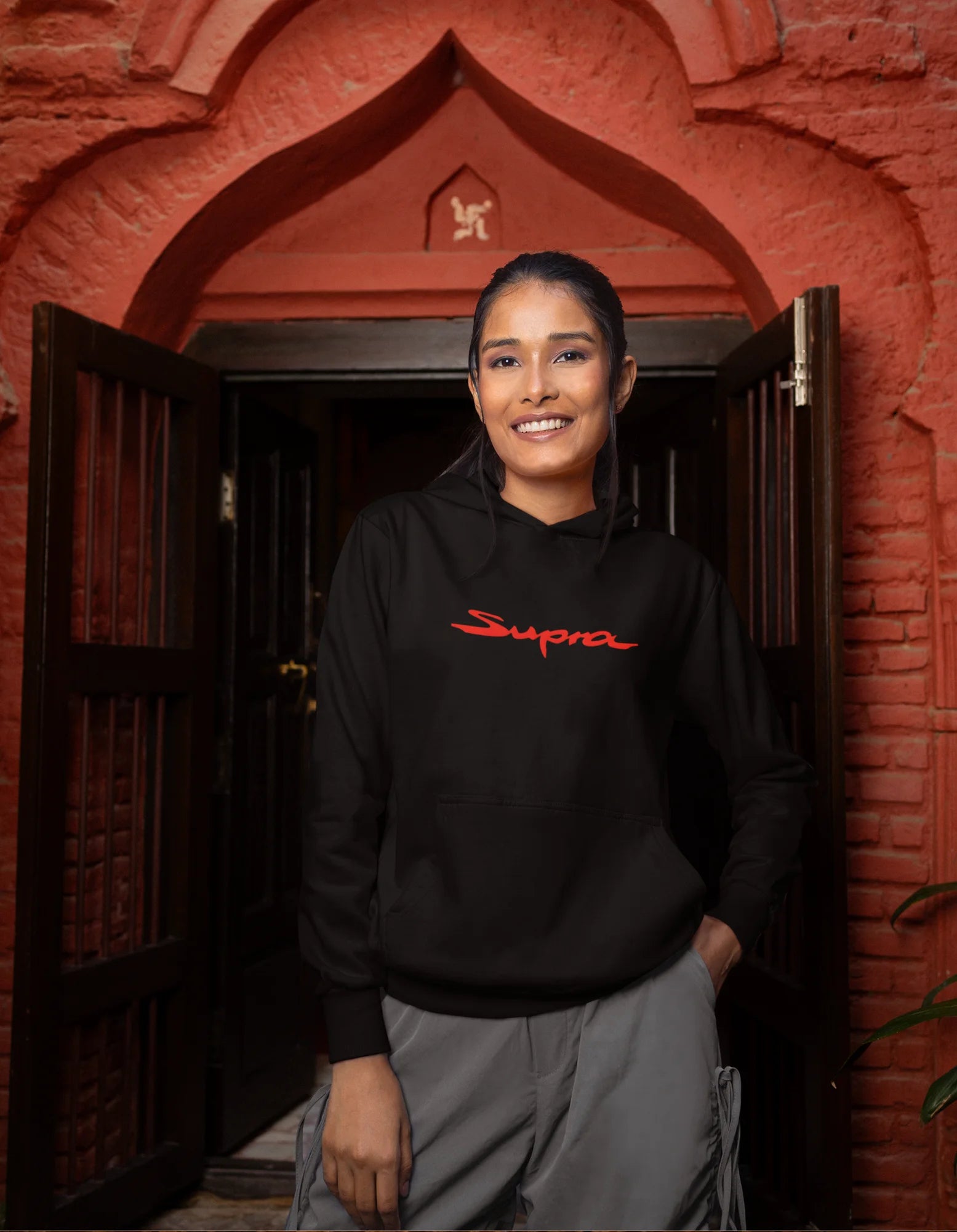 Second front view of a female model wearing a black hoodie featuring a Toyota Supra design, exuding speed and power.