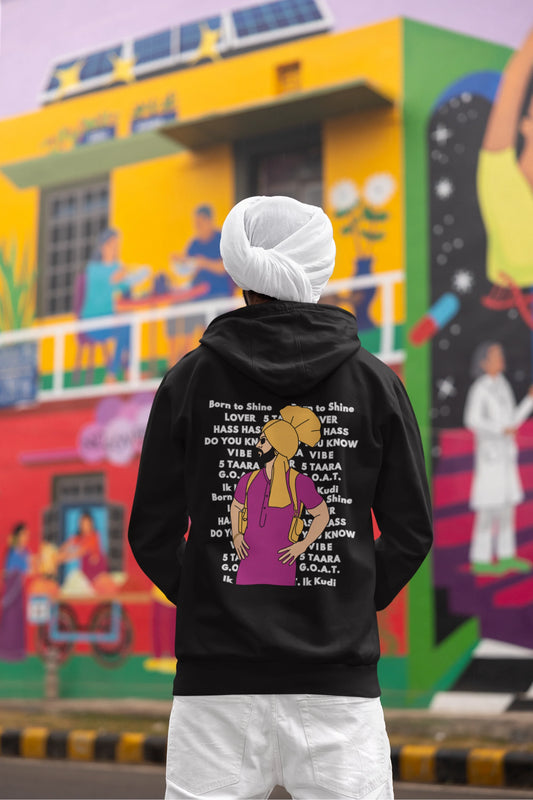 Back view of a male model wearing a black hoodie with a portrait of Diljit Dosanjh and lyrics from the song "Ikk Kudi."