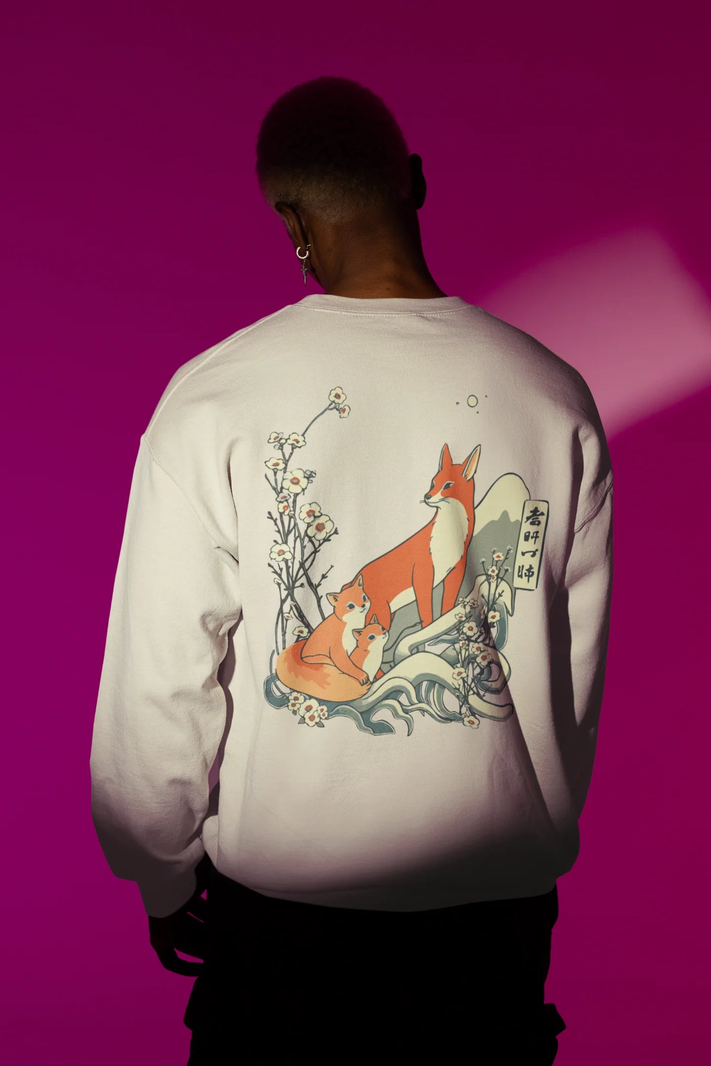 Back view male model wearing a cream sweatshirt with a design of a fox and its cub in a traditional Japanese landscape.
