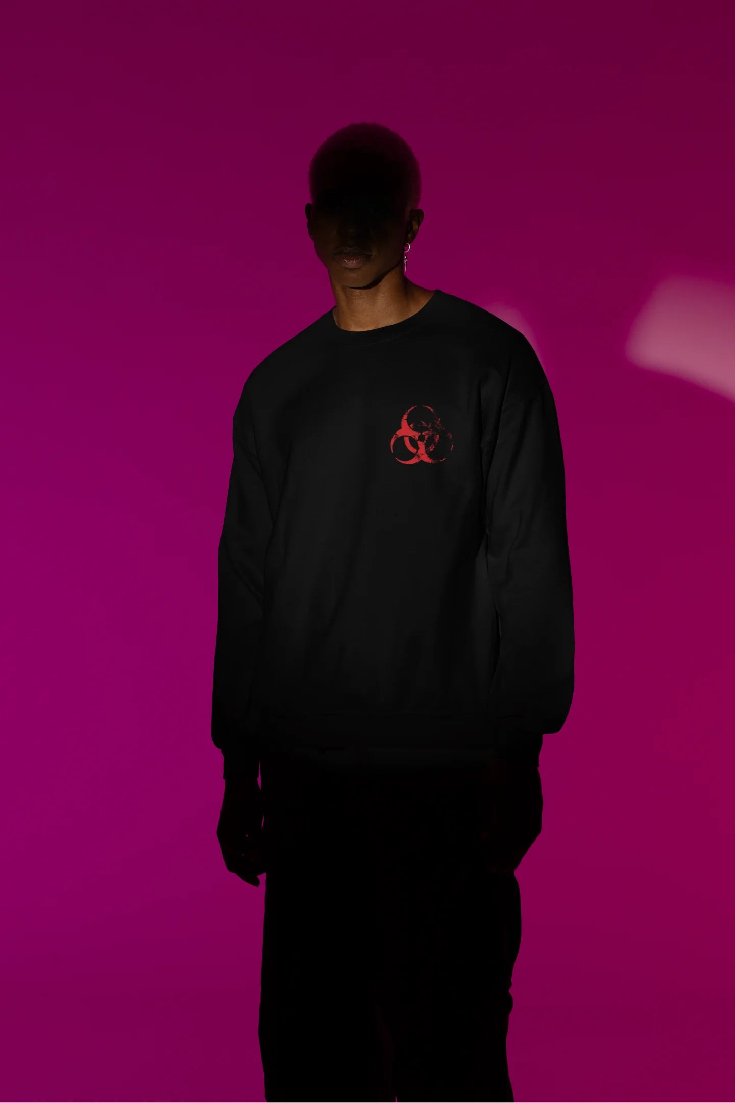 Second front view of a male model wearing a black brutalist sweatshirt with a stylized, concrete-like image of an abstract statue and the word "Experiment" prominently displayed.