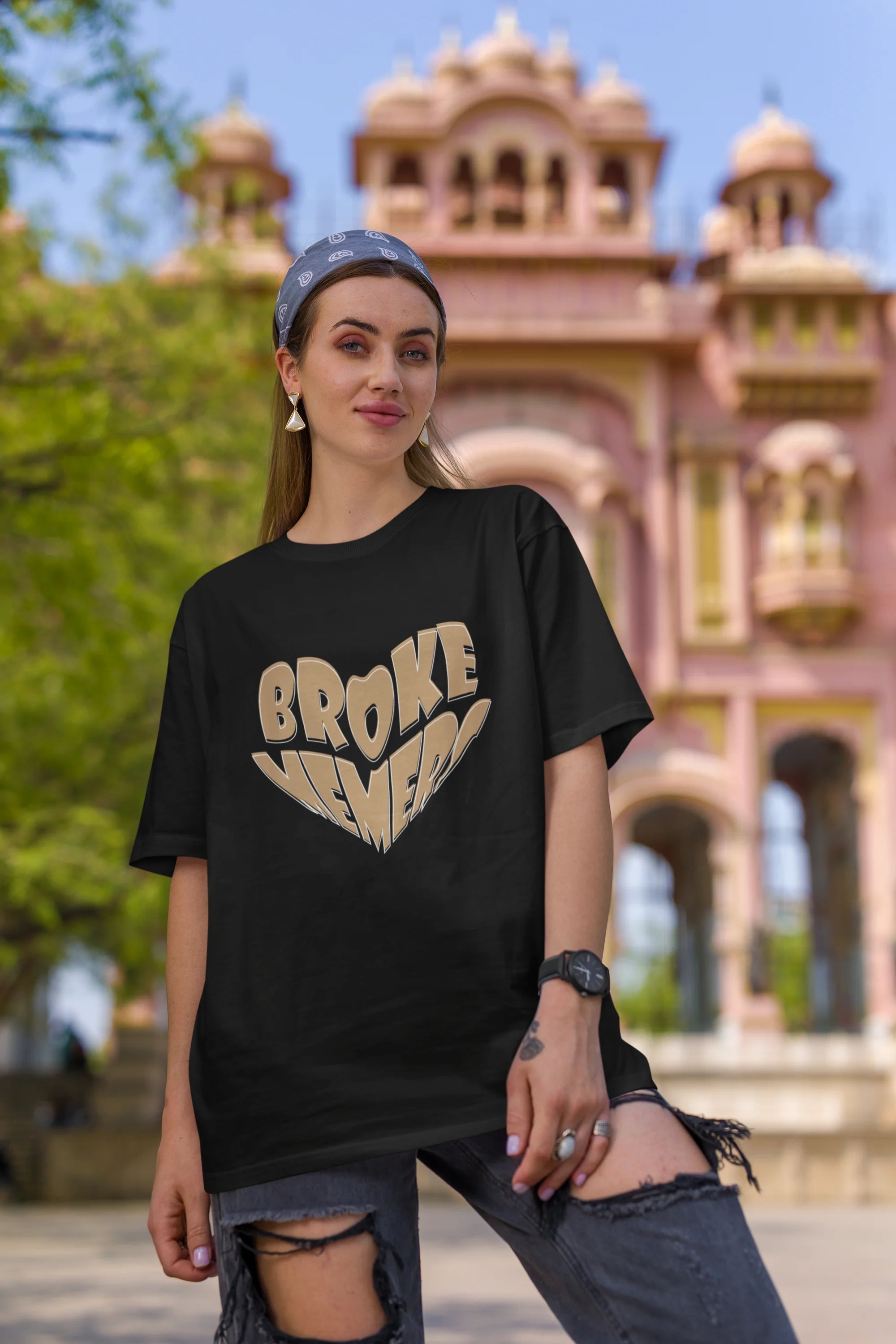 First front view of female model wearing a black oversized t-shirt featuring the "Broke Memers" logo creatively shaped like a heart. Ideal for fans of Broke Memers who love quality and fashionable clothing.