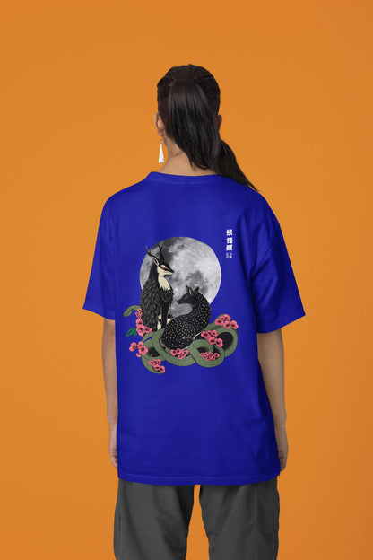 Back view of a female model wearing an oversized royal blue t-shirt featuring a detailed illustration of a gray wolf howling at a full moon in a nighttime setting.