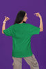 Back view of a female model wearing a forest green oversized t-shirt with the text 