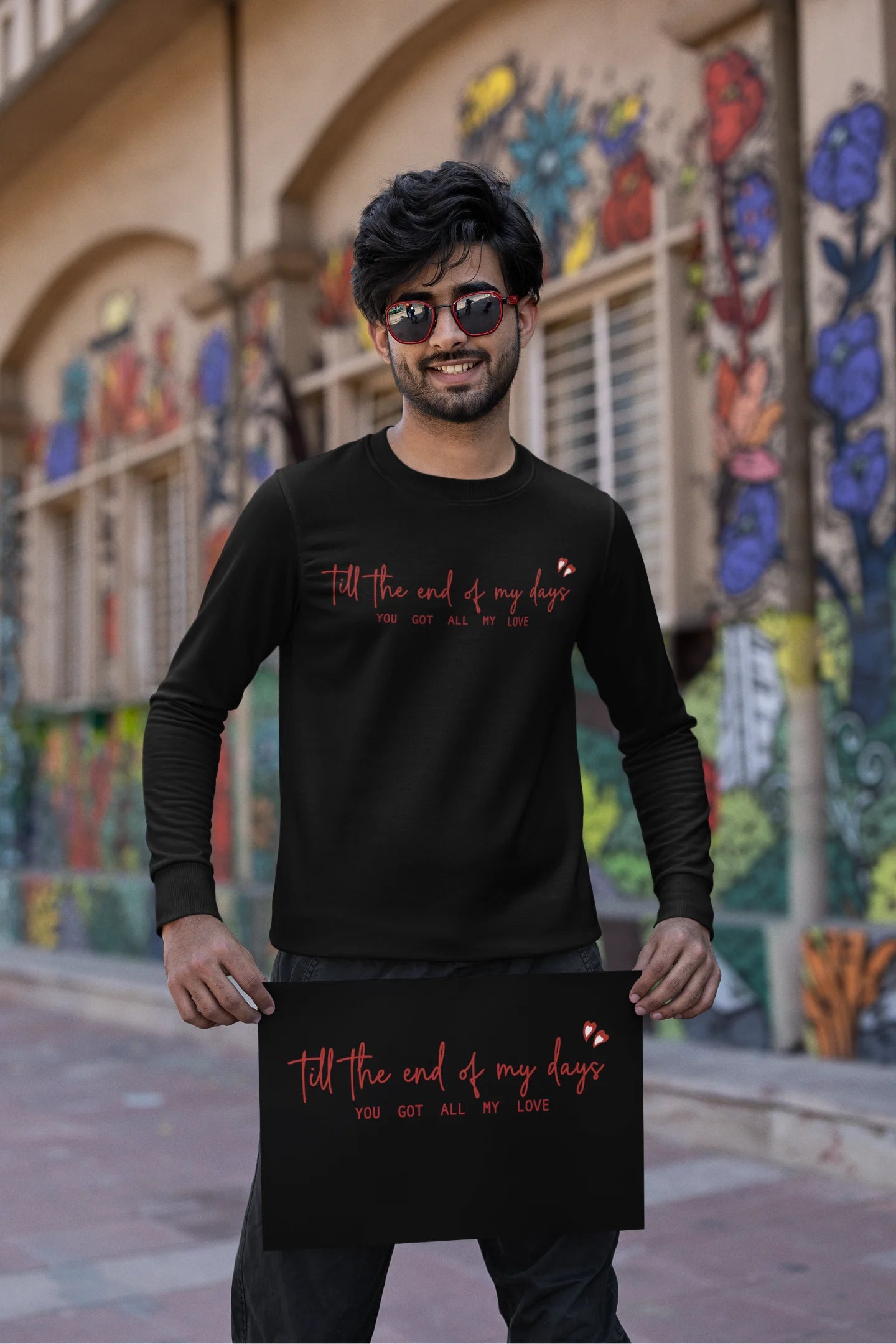 First front view of a male model wearing a black sweatshirt with a heart design and the text "All My Love".