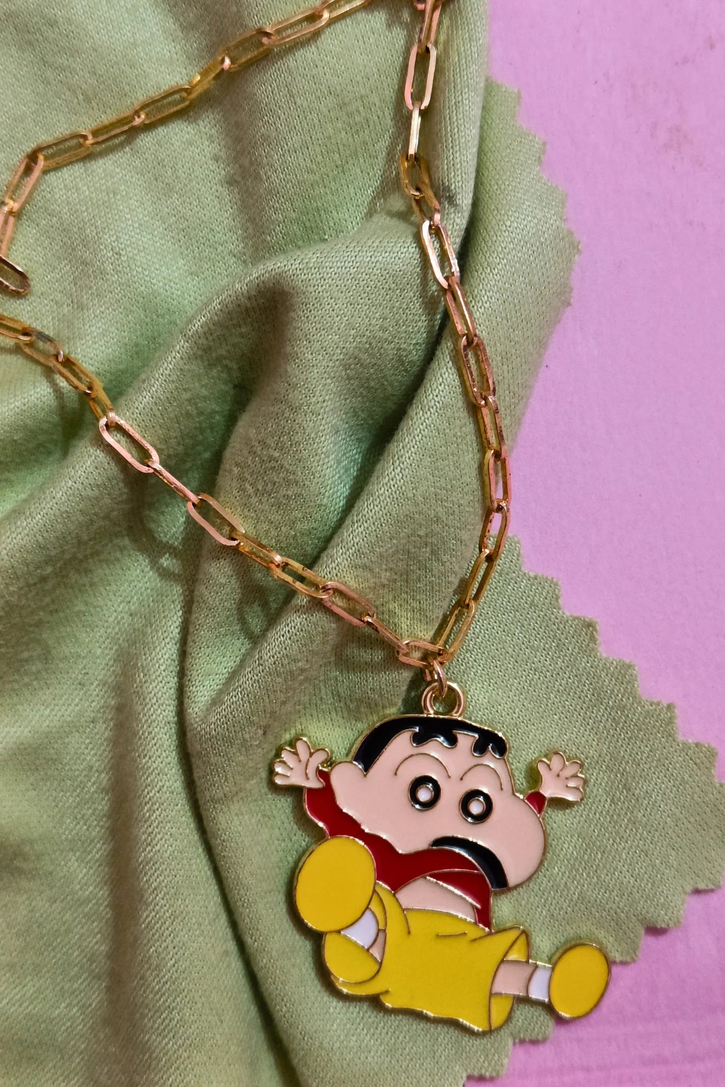 4th view of a gold chain necklace with a small pendant depicting Shin Chan jumping in the air and shouting "Hurray!