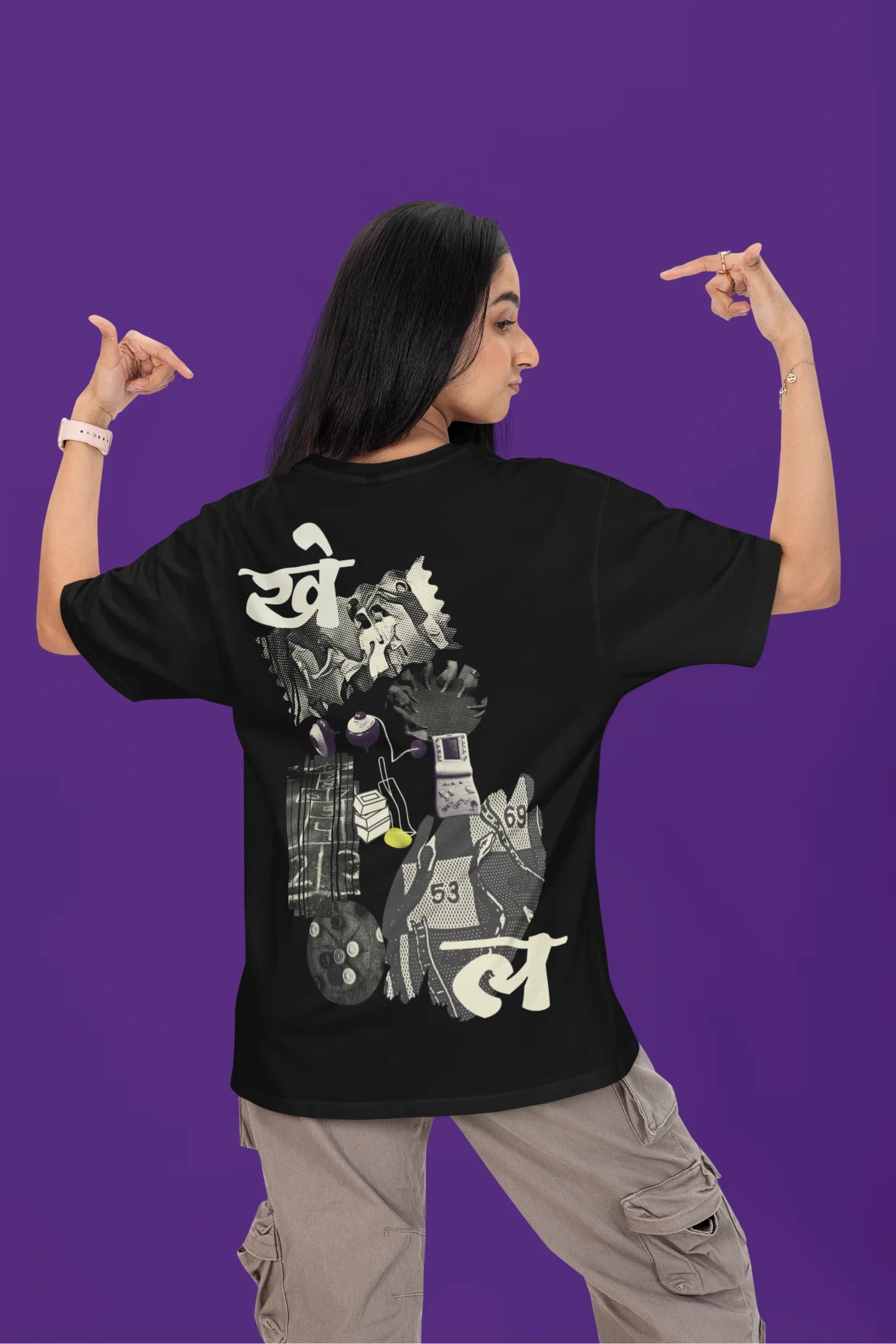 Back view of a female model wearing a black oversized t-shirt featuring a collage of illustrations or symbols representing various childhood games commonly played by kids in India.