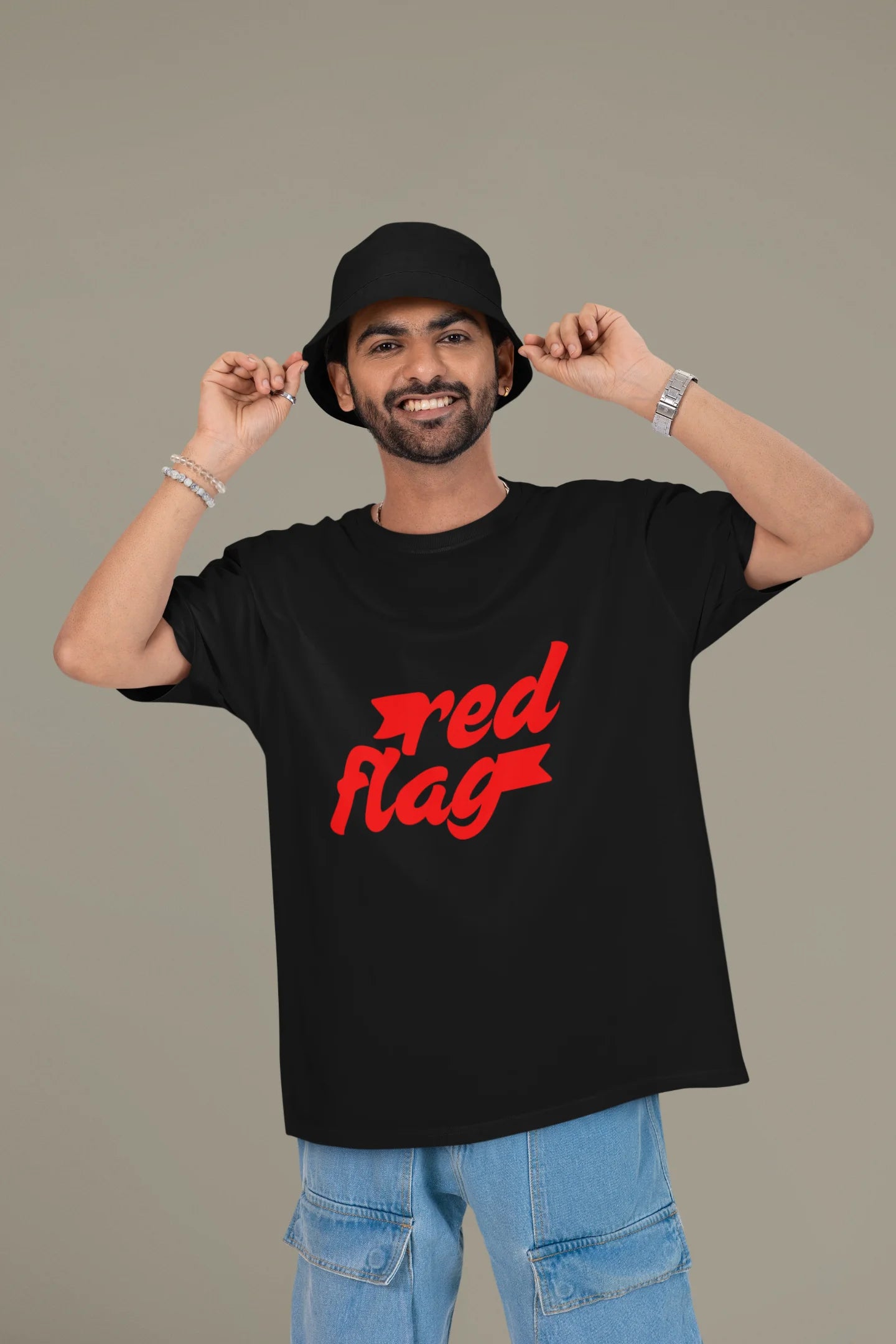 2nd front view of a male model wearing an black oversized t-shirt with the text "Red Flag" printed on it.