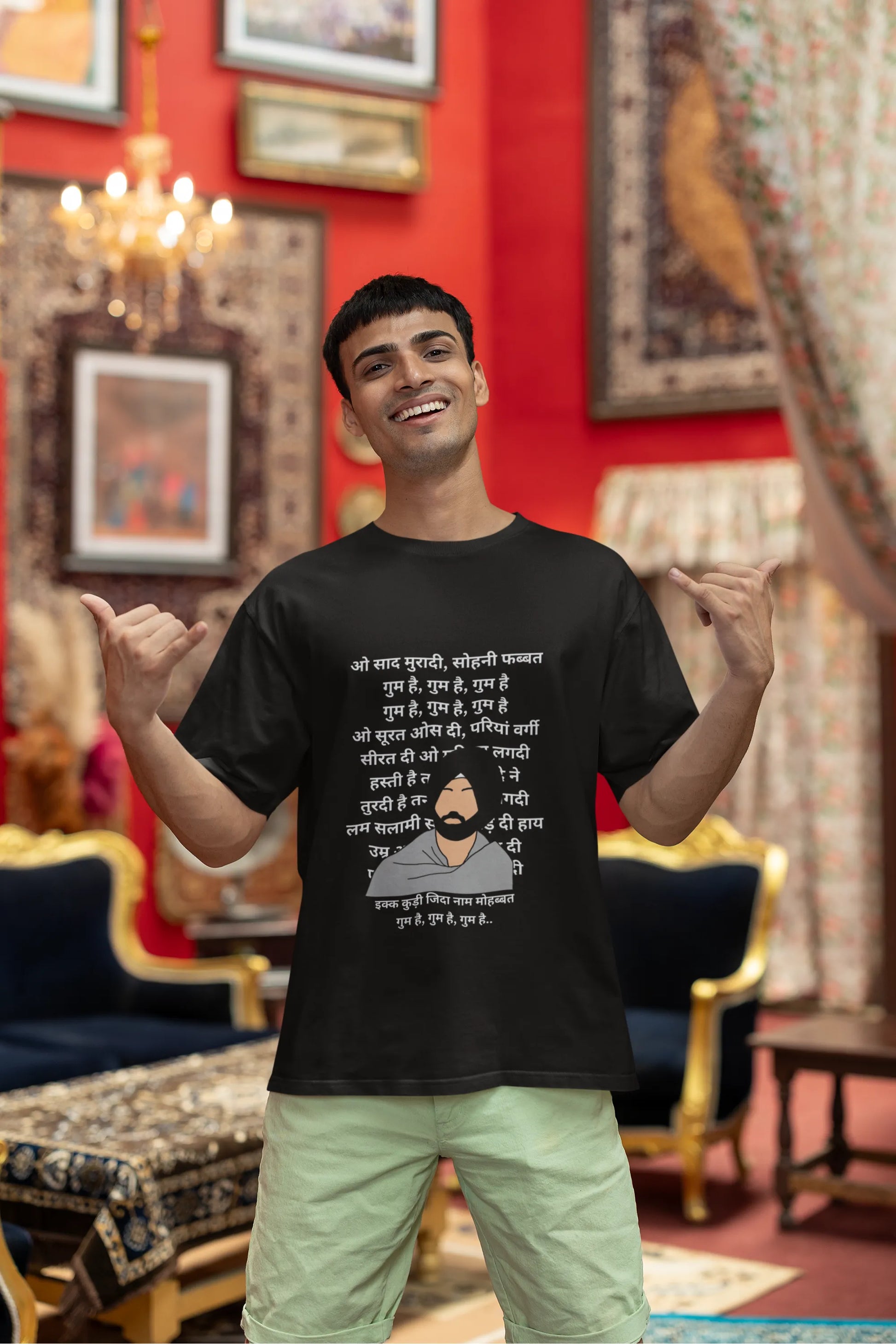 First front view of a female model wearing a black oversized  T-shirt with a Diljit Dosanjh portrait  with lyrics from the song "Ikk Kudi" in the background.
