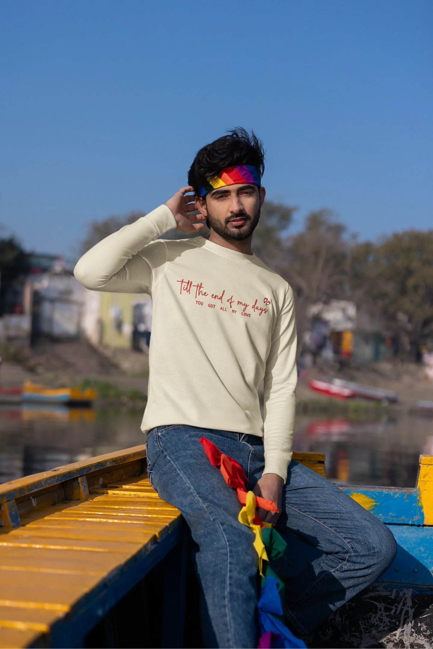 Third front view of a male model wearing a cream sweatshirt with a heart design and the text "All My Love".