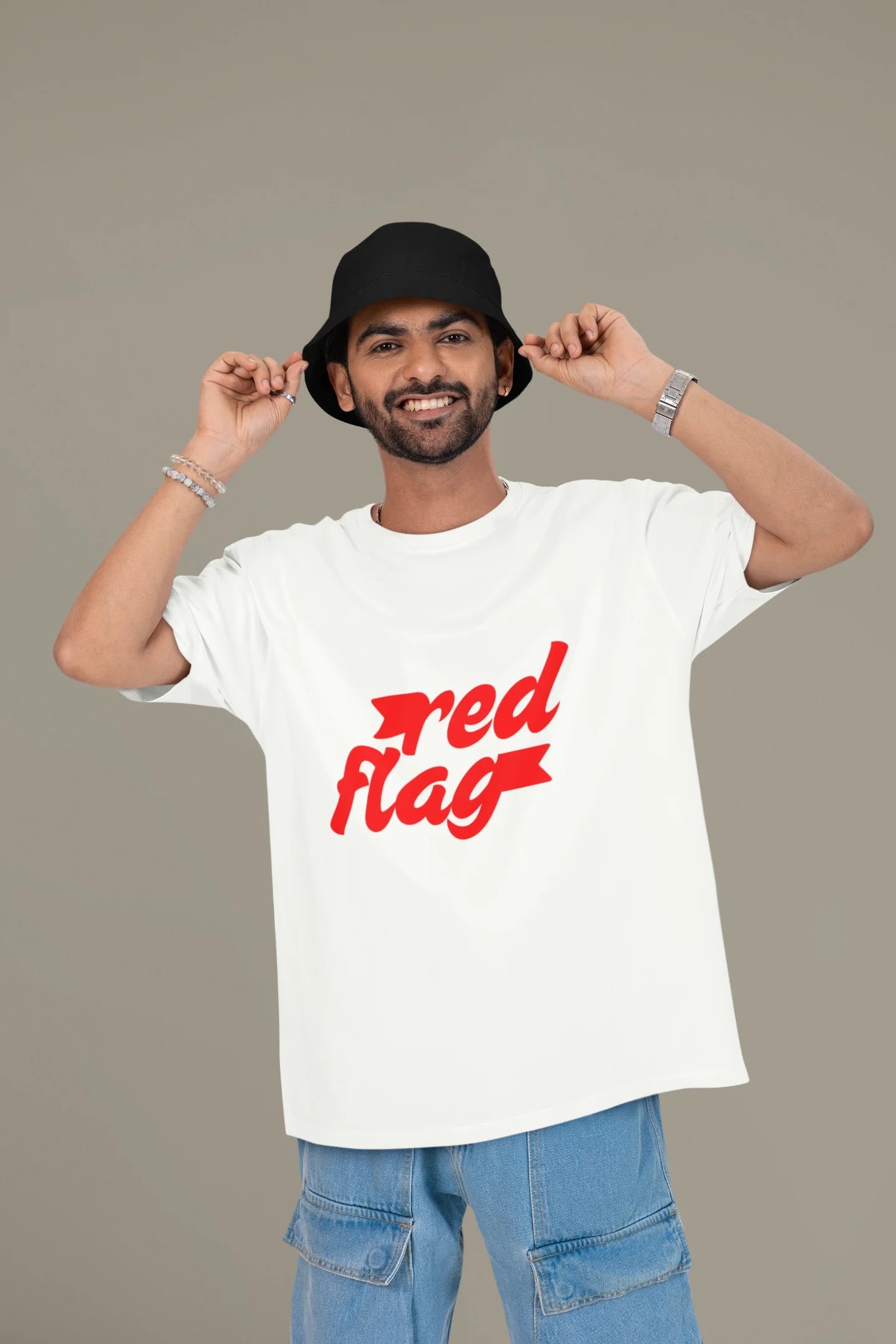 First front view of a male model wearing an off-white oversized t-shirt with the text "Red Flag" printed on it.