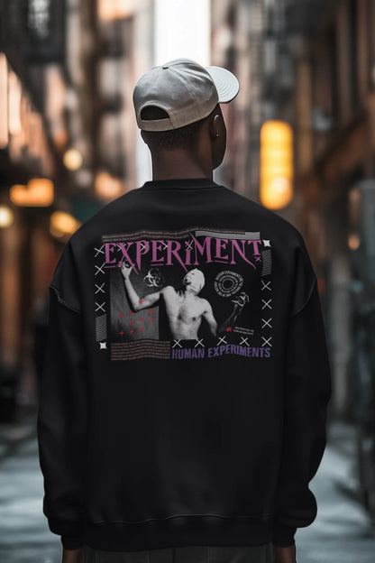 First back view of a male model wearing a black brutalist sweatshirt with a stylized, concrete-like image of an abstract statue and the word "Experiment" prominently displayed.