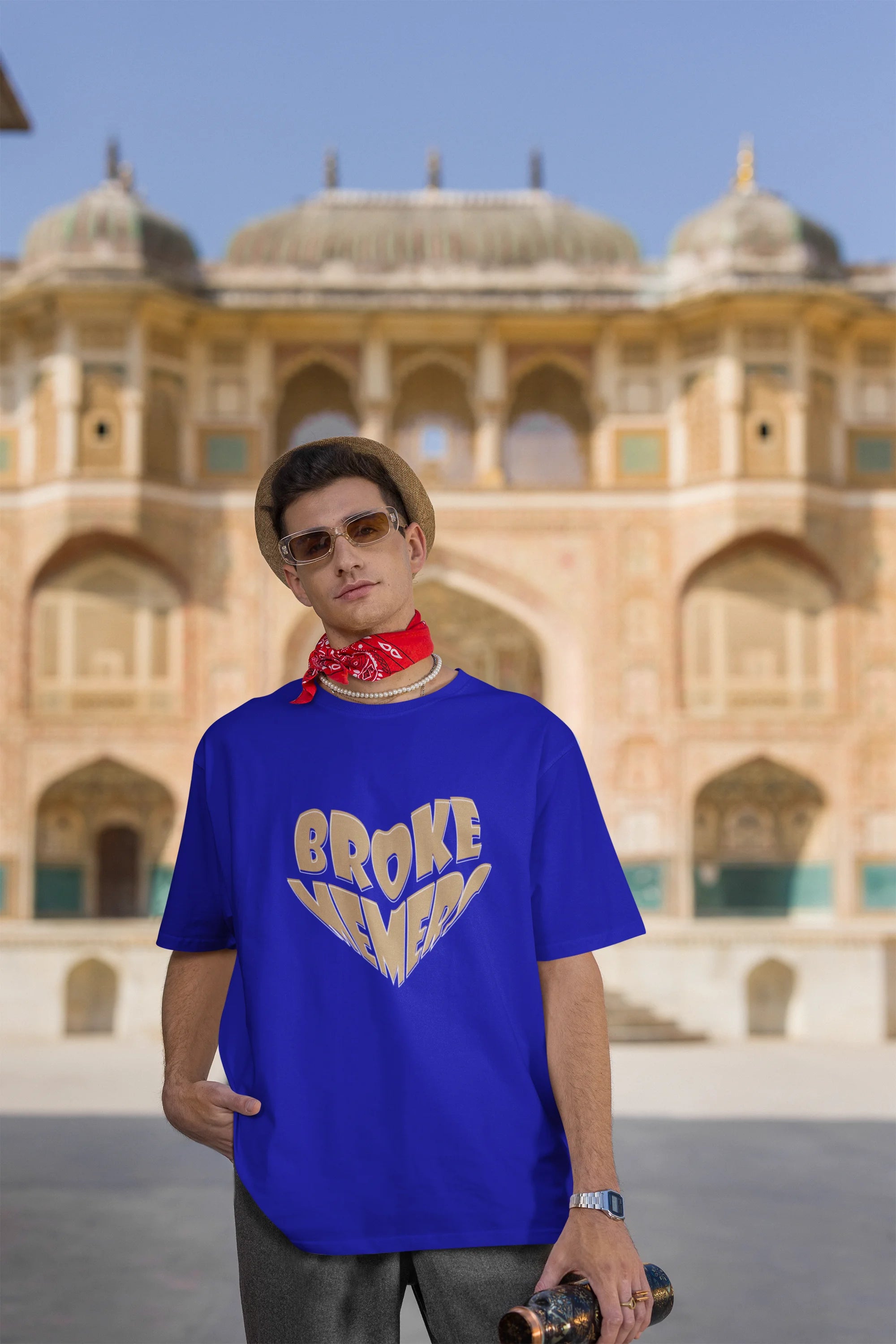 Third front view of male model wearing a royal blue oversized t-shirt featuring the "Broke Memers" logo creatively shaped like a heart. Ideal for fans of Broke Memers who love quality and fashionable clothing.