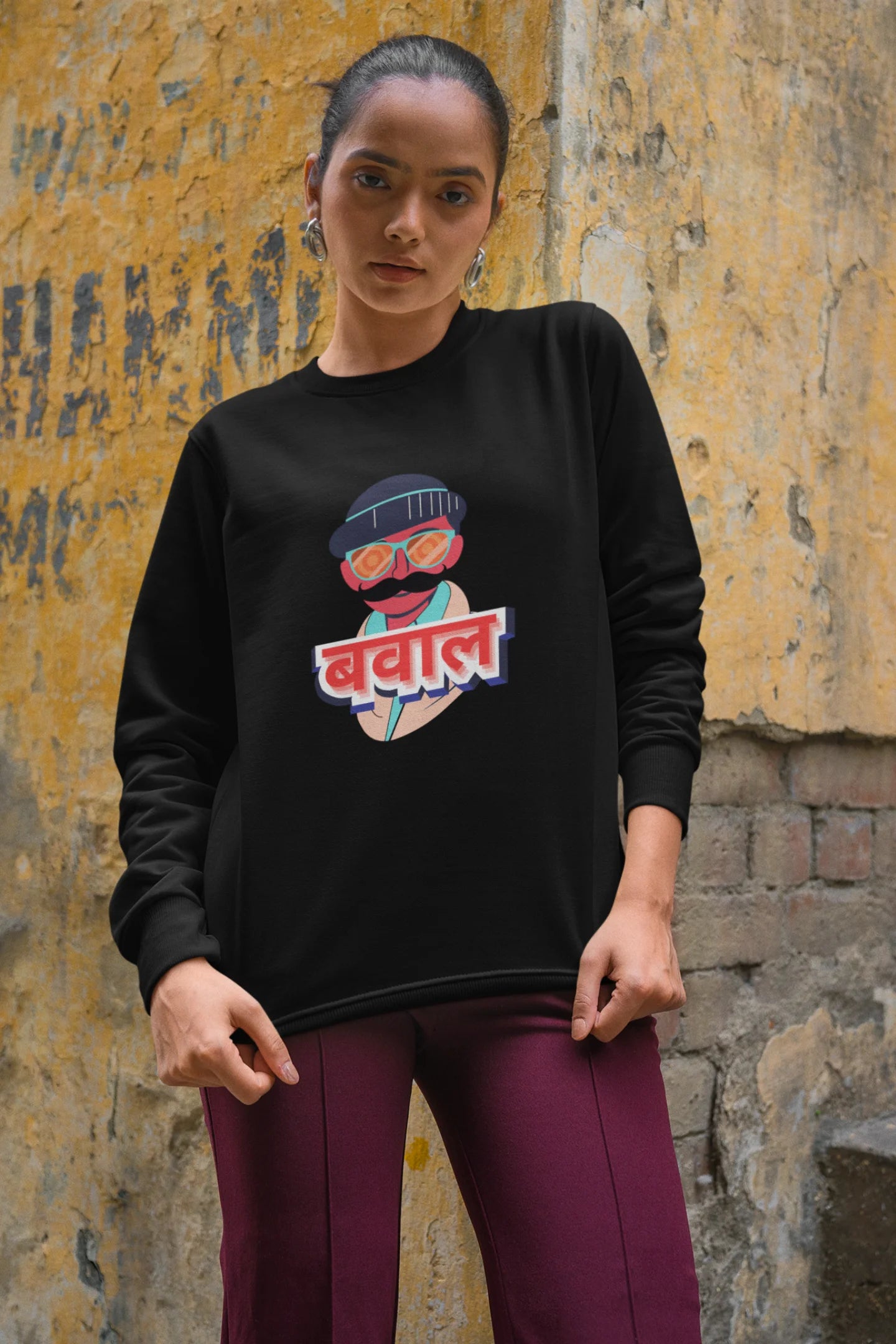 3rd front view of a female model wearing a black oversized t-shirt with "Bawaal" in a stylish Hindi.