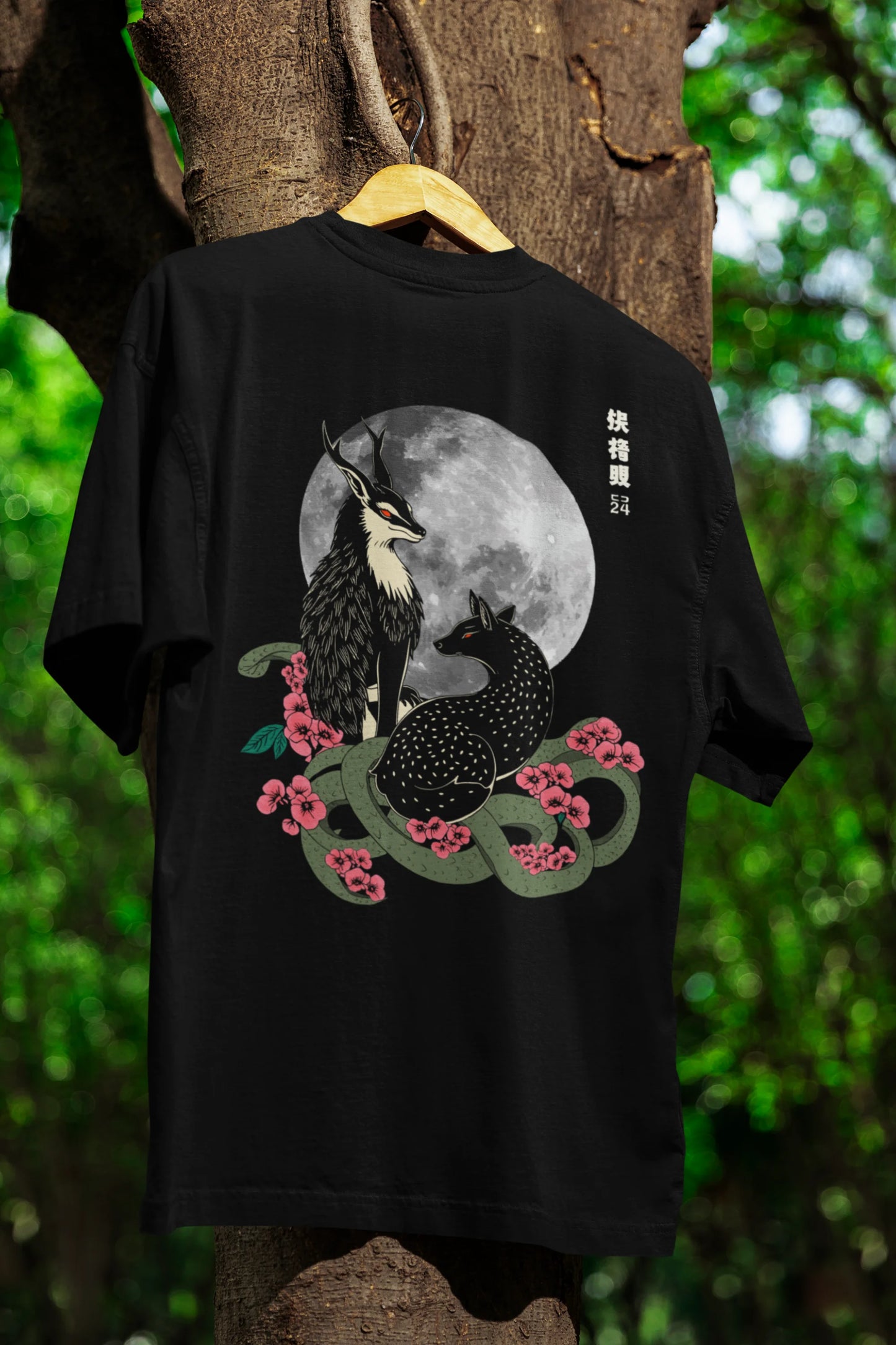 An oversized black t-shirt featuring a detailed illustration of a gray wolf howling at a full moon in a nighttime setting.