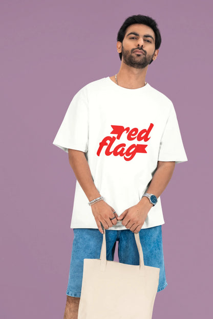 3rd front view of a male model wearing an off-white oversized t-shirt with the text "Red Flag" printed on it.