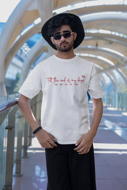 Second front view of a male model wearing a off-white oversized t-shirt with a heart design and the text "All My Love".