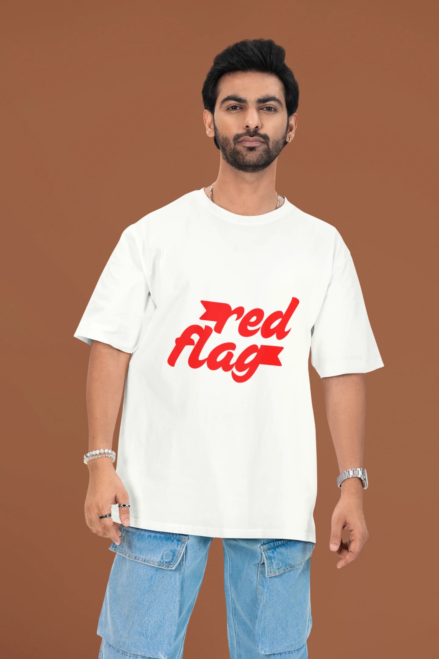 2nd front view of a male model wearing an off-white oversized t-shirt with the text "Red Flag" printed on it.