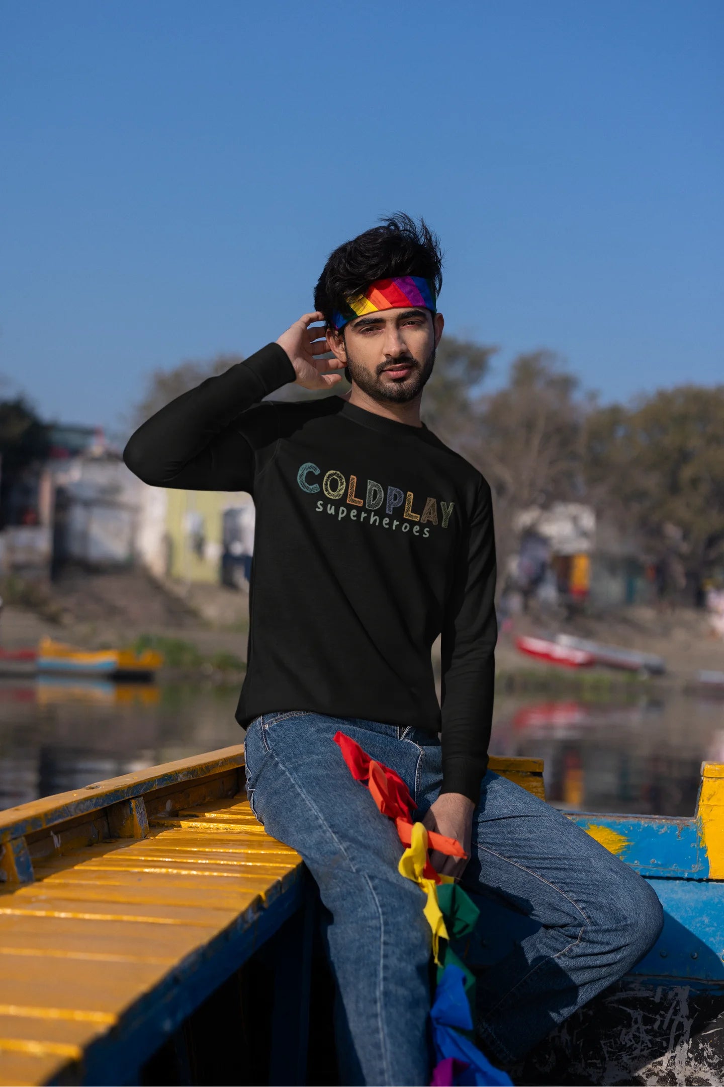 Second front view of a male model wearing an black sweatshirt with a design inspired by the "Something Just Like This" music video, featuring the word "Superheroes".
