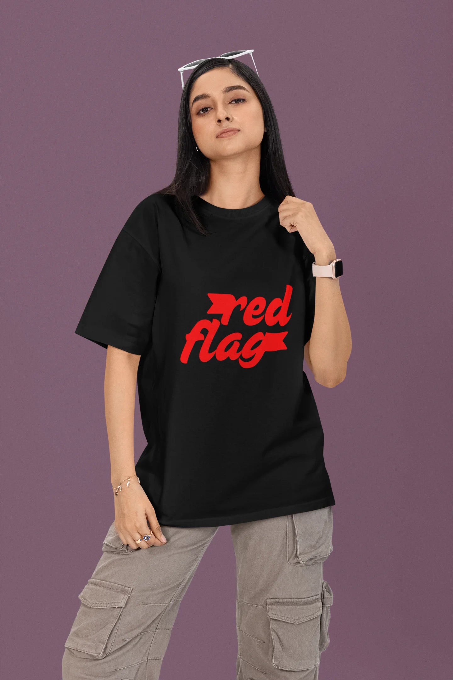 2nd front view of a female model wearing an black oversized t-shirt with the text "Red Flag" printed on it.