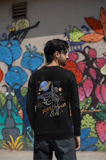 Back view of a male model wearing an black sweatshirt with a design inspired by the "Something Just Like This" music video, featuring the word "Superheroes".
