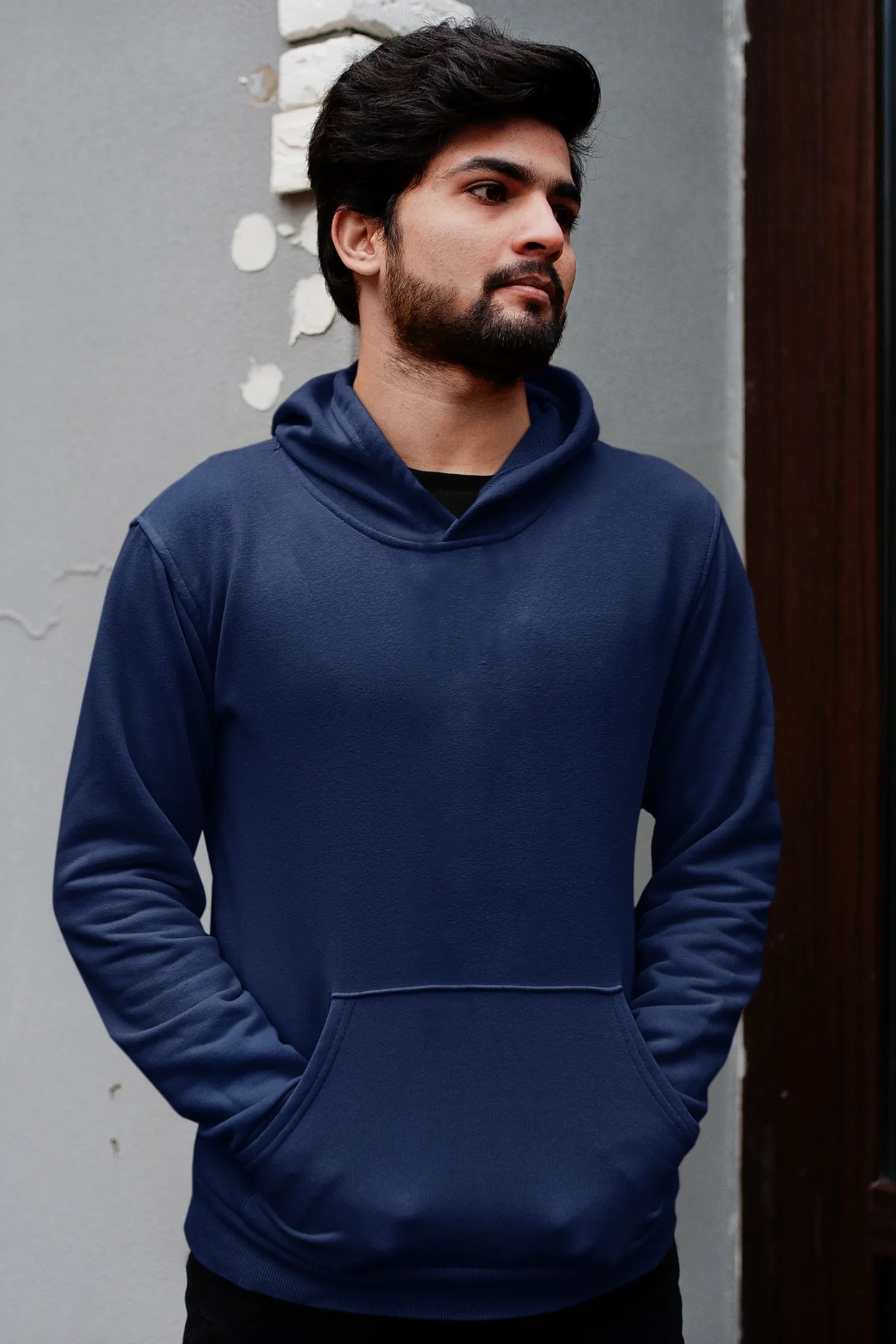 First front view of a male model wearing a navy blue hoodie featuring a Range Rover Defender design, exuding power and ruggedness.