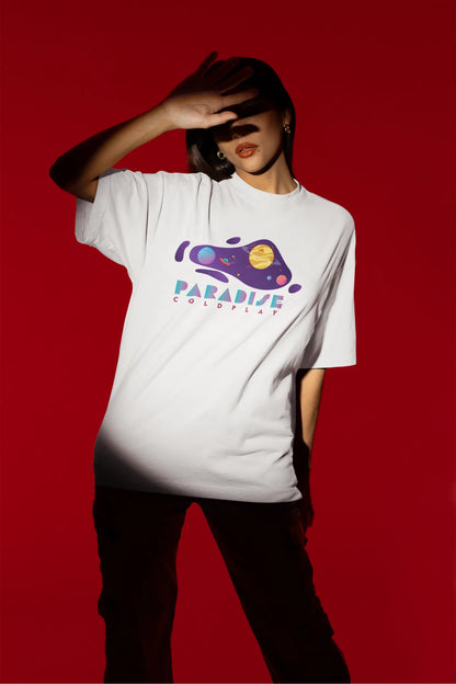 Third front view of a female model wearing an white oversized t-shirt with the "Paradise" album artwork by Coldplay.
