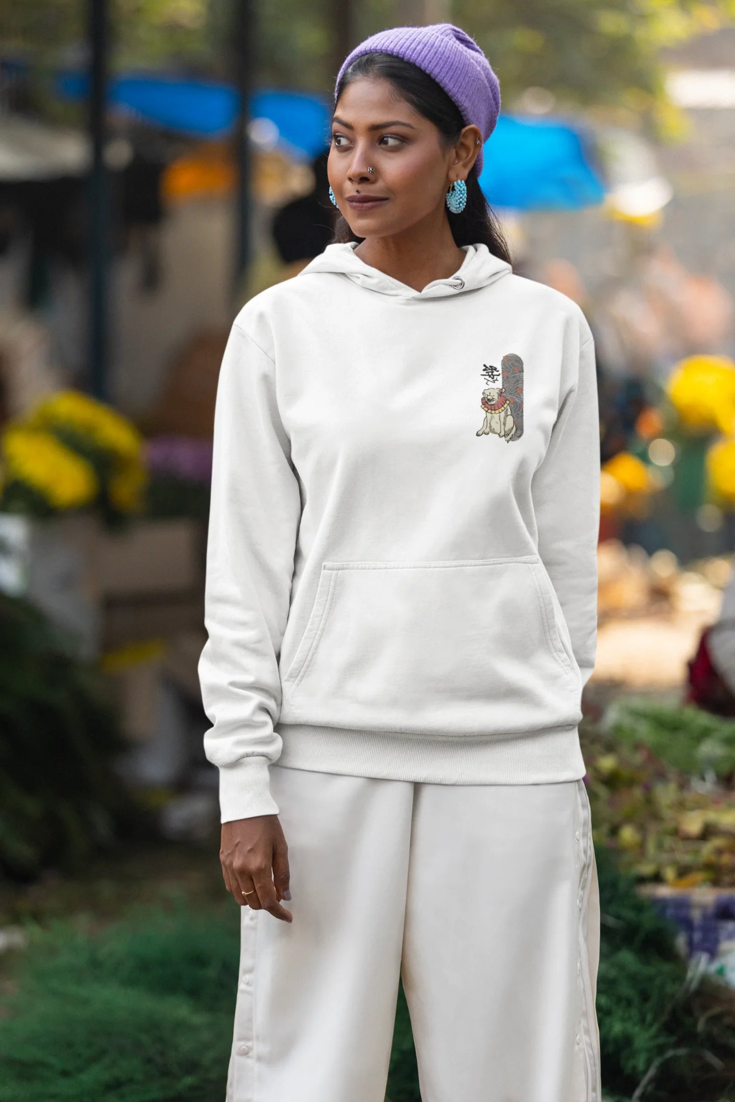 First front view of a female model wearing a cream hoodie with a design of a mythical Japanese dog.