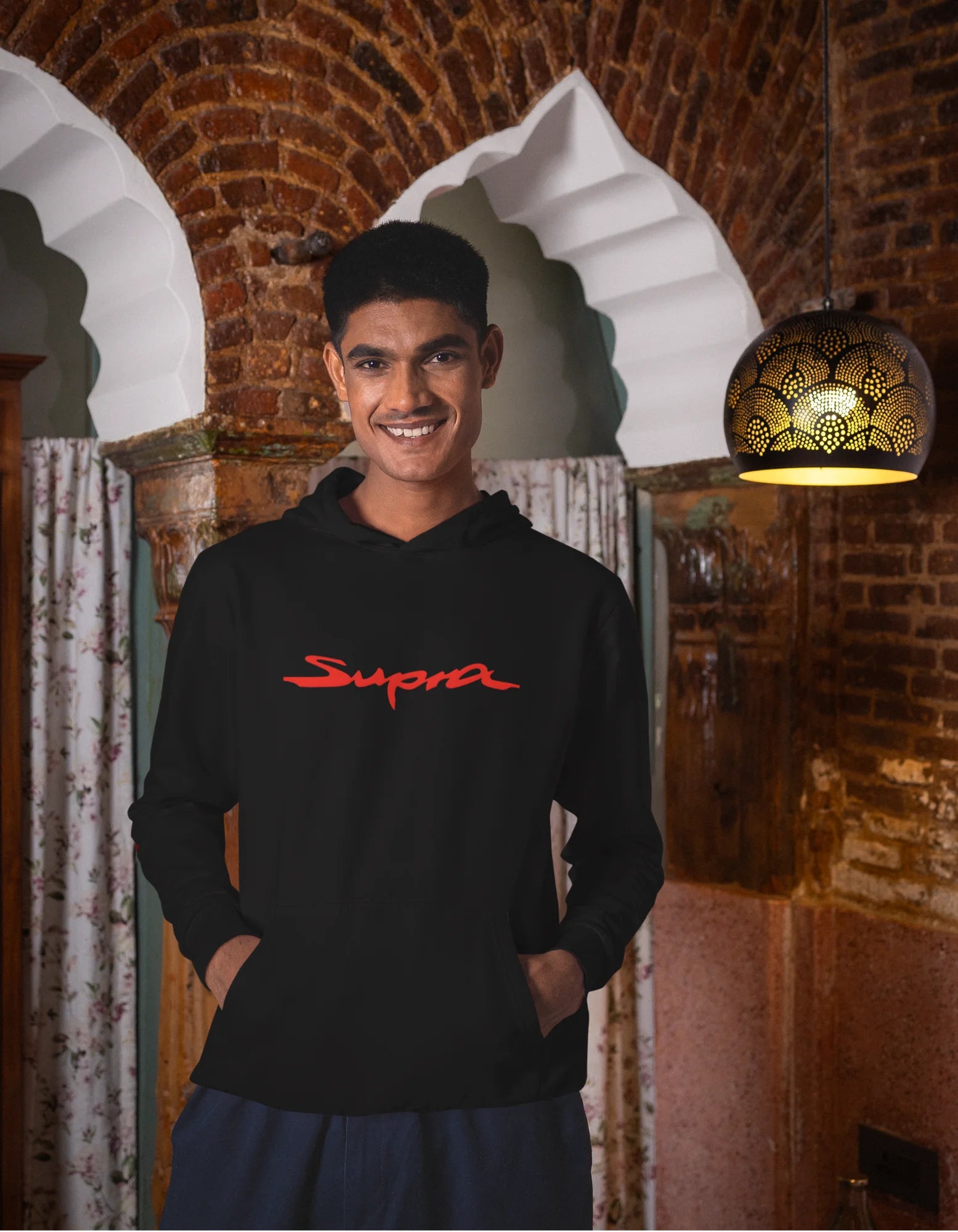 Third front view of a male model wearing a black hoodie featuring a Toyota Supra design, exuding speed and power.