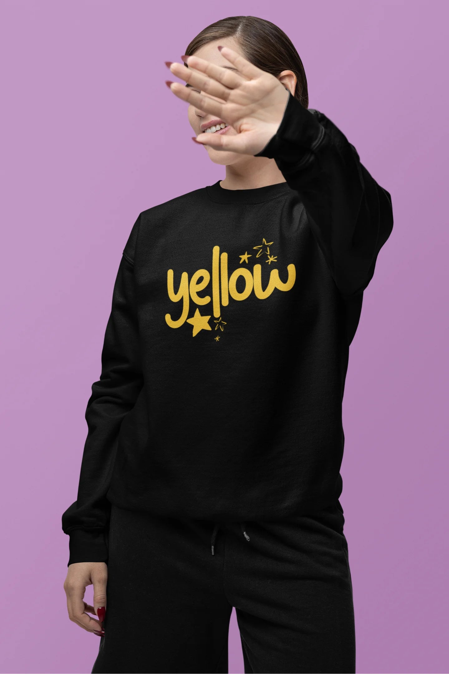 Second front view of a female model wearing a black sweatshirt with the "Yellow" album artwork by Coldplay.