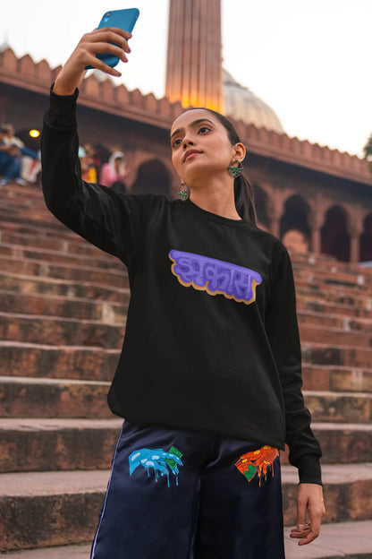 2nd front view of a female model wearing an black sweatshirt featuring "Jhakas" in a stylish font.