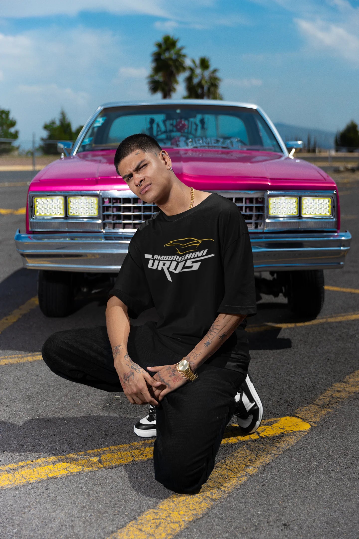 Front view of a male model wearing a black oversized t-shirt featuring a design of a Lamborghini Urus.