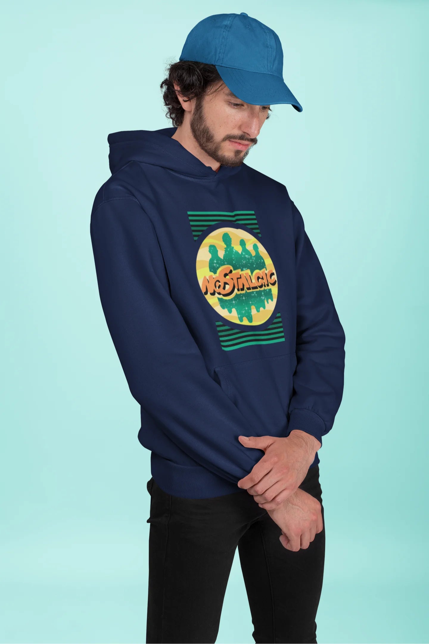 2nd front view of a male model wearing an navy blue hoodie with a shadow silhouette of the Coldplay band members and the word "Nostalgic" printed on it.