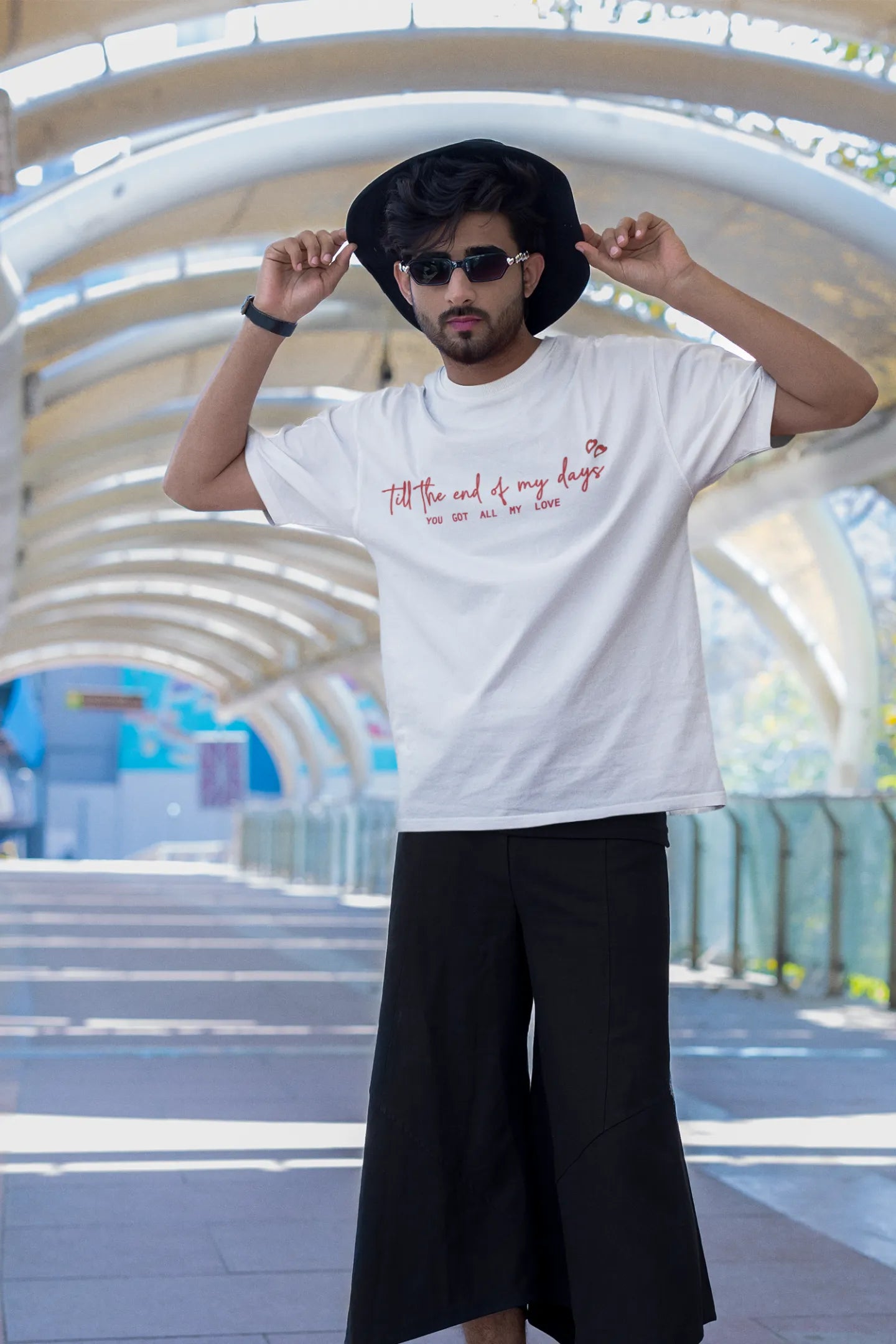 First front view of a male model wearing a off-white oversized t-shirt with a heart design and the text "All My Love".