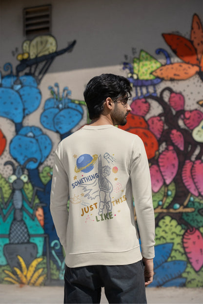 Back view of a male model wearing an cream sweatshirt with a design inspired by the "Something Just Like This" music video, featuring the word "Superheroes".