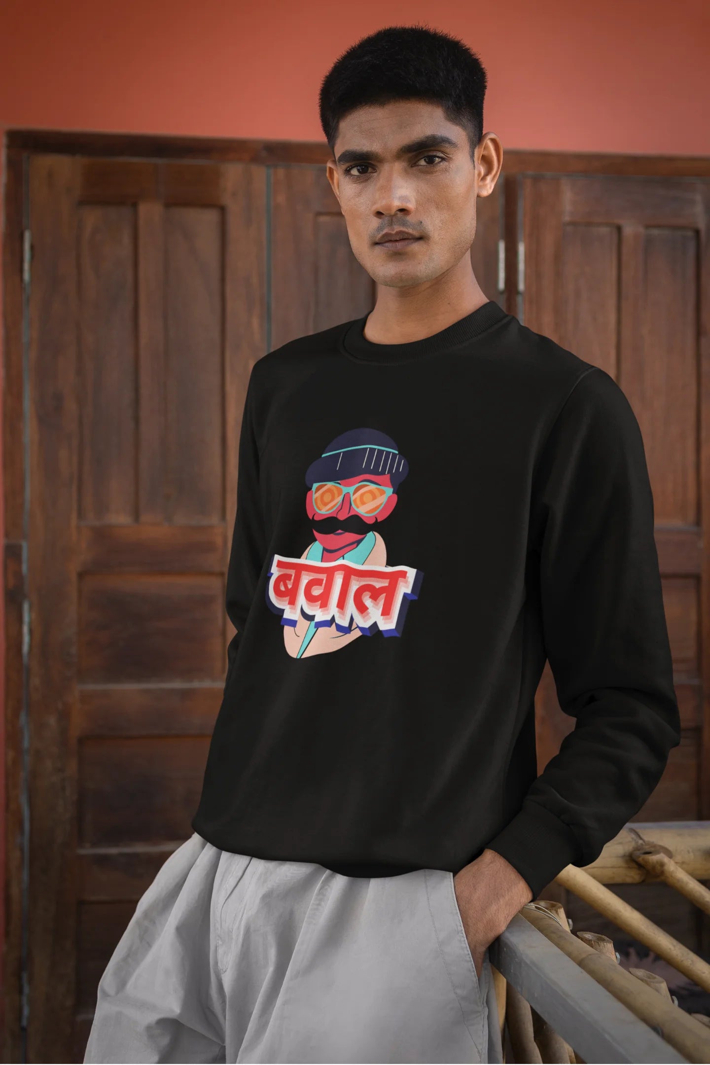 2nd front view of a male model wearing a black oversized t-shirt with "Bawaal" in a stylish Hindi.