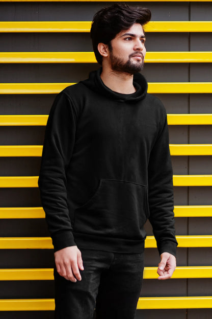 First front view of a male model wearing a black hoodie with a design of a wildcat sitting on ocean waves.