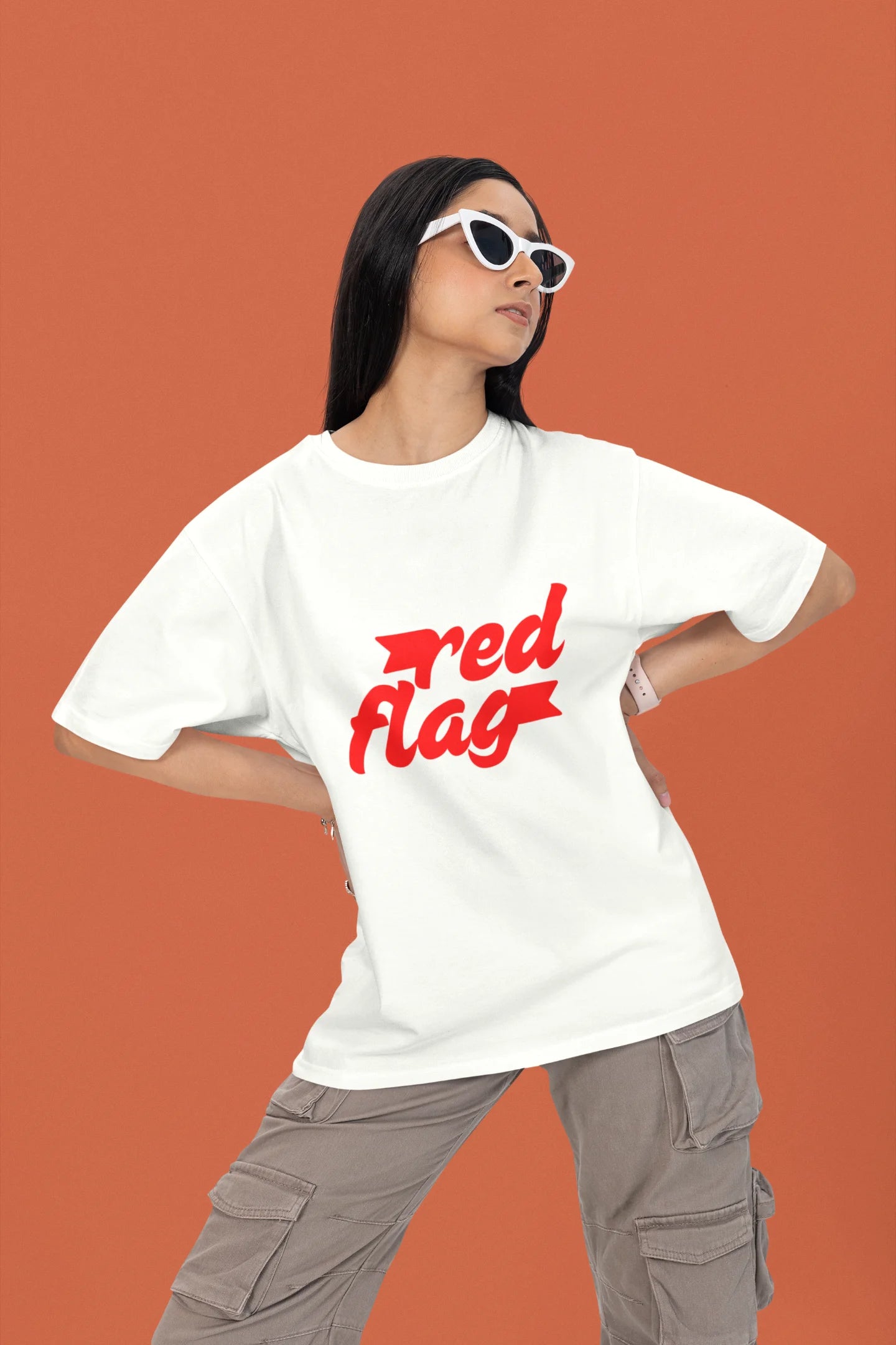 First front view of a female model wearing an off-white oversized t-shirt with the text "Red Flag" printed on it.