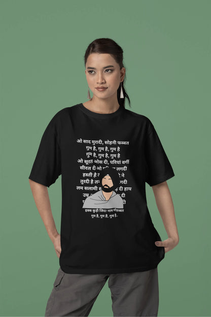 Second front view of a female model wearing a black oversized  T-shirt with a Diljit Dosanjh portrait  with lyrics from the song "Ikk Kudi" in the background.