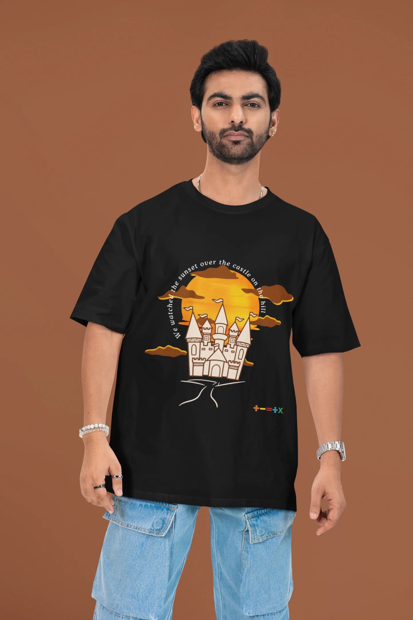 3rd front view of a male model wearing a black oversized t-shirt featuring a nostalgic sunset and castle design, related to Ed Sheeran's "Castle on the Hill."