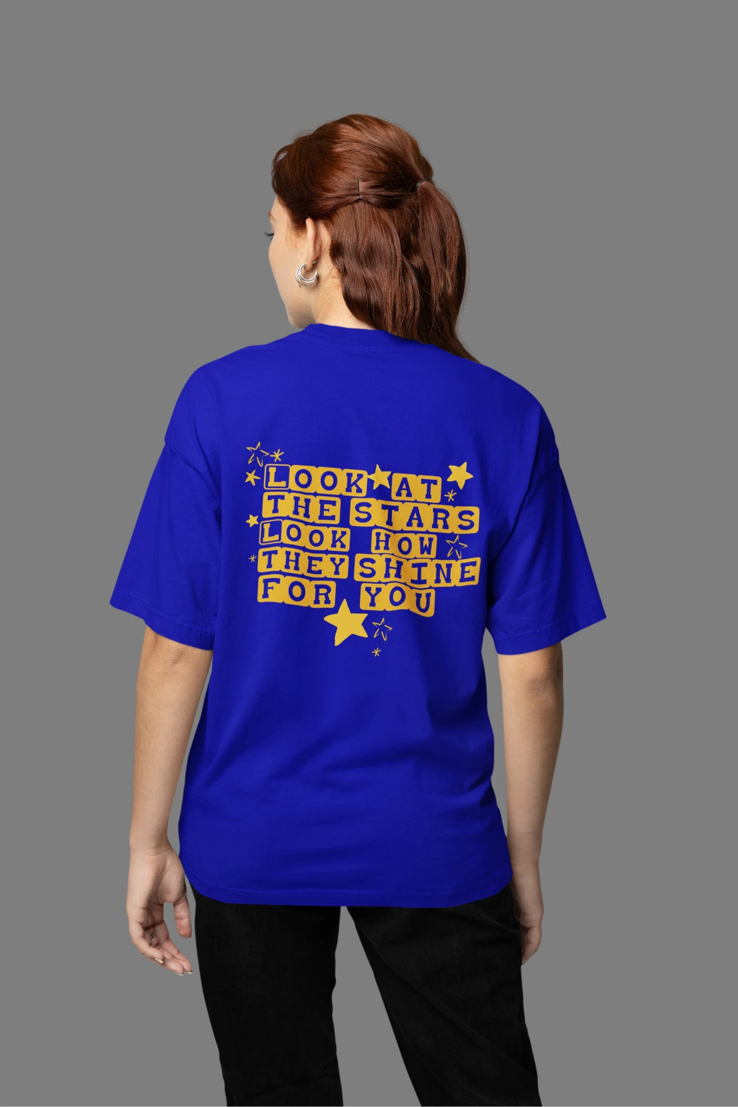 Back view of a female model wearing an royal blue oversized t-shirt with the "Yellow" album artwork by Coldplay.