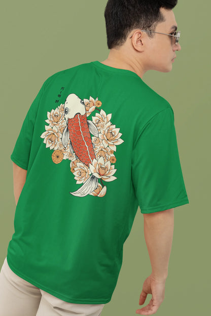 Back view of a male model wearing a forest green oversized tee with a design of a koi fish swimming in a bed of flowers.