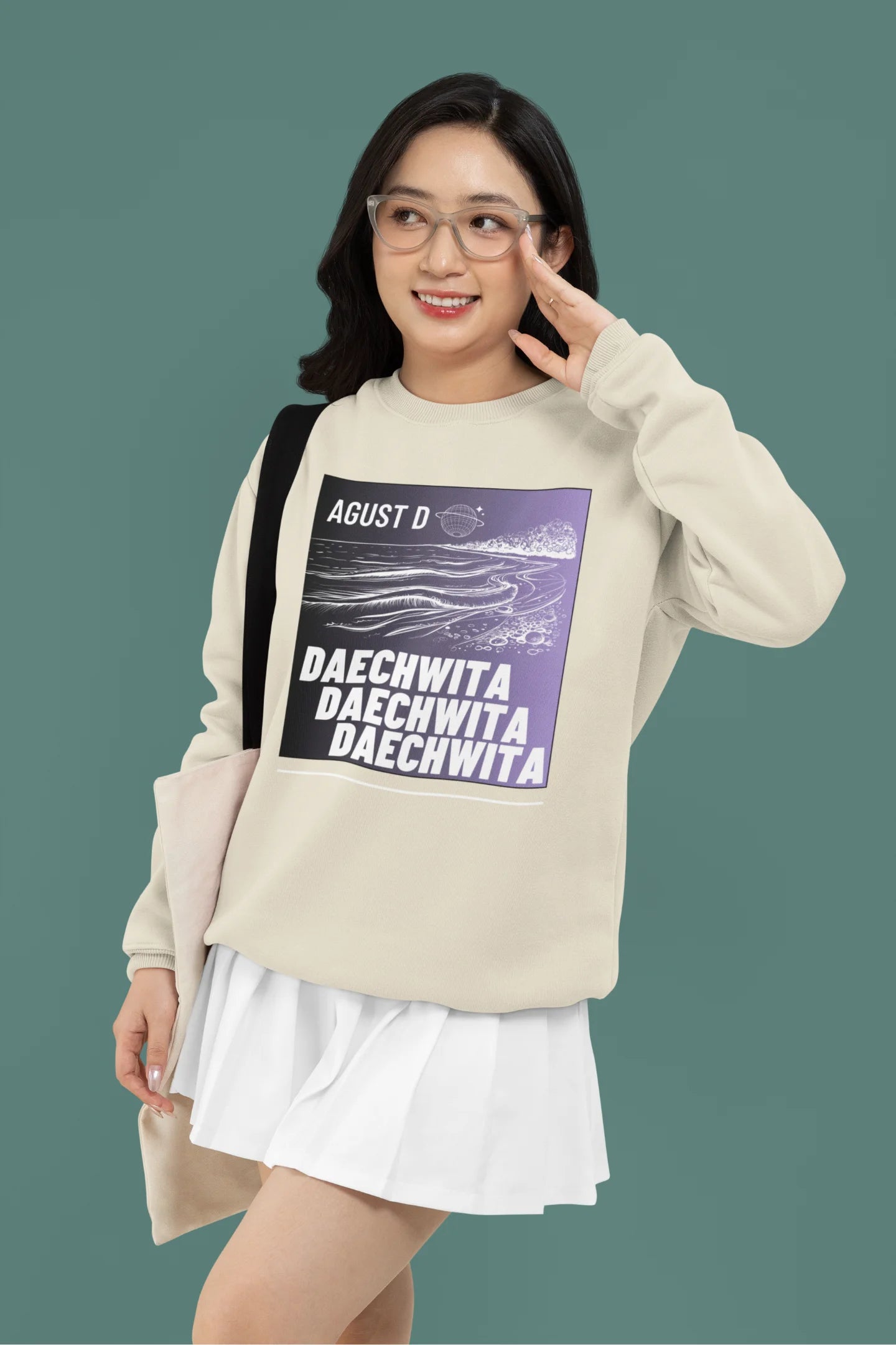Second front view of a female model wearing a cream sweatshirt featuring a bold design inspired by BTS member Suga's alter ego, August D. Ideal for BTS fans (ARMY) and K-Pop enthusiasts who love rap music and artist individuality.