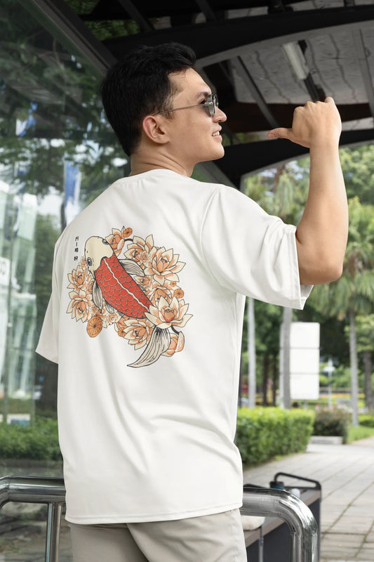 2nd back view of a male model wearing a off-white oversized tee with a design of a koi fish swimming in a bed of flowers.