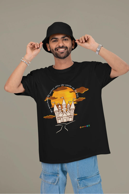 First front view of a male model wearing a black oversized t-shirt featuring a nostalgic sunset and castle design, related to Ed Sheeran's "Castle on the Hill."