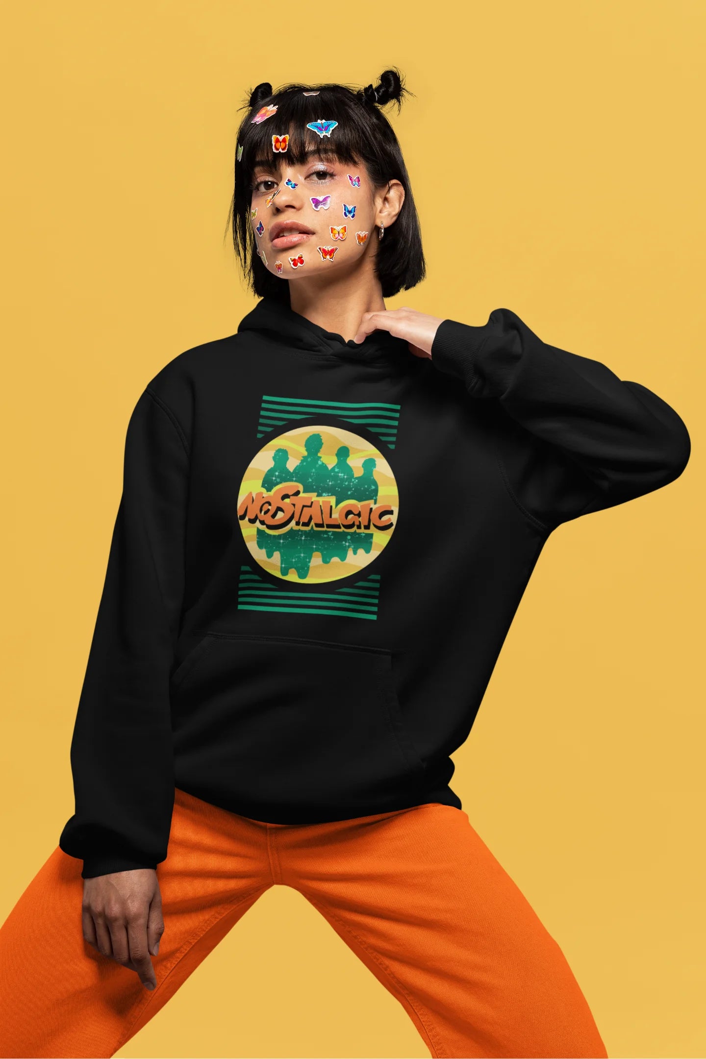 First front view of a female model wearing an black hoodie with a shadow silhouette of the Coldplay band members and the word "Nostalgic" printed on it.